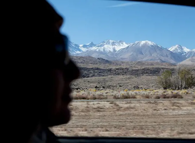 Silhouette of a person's face with mountain range in the background