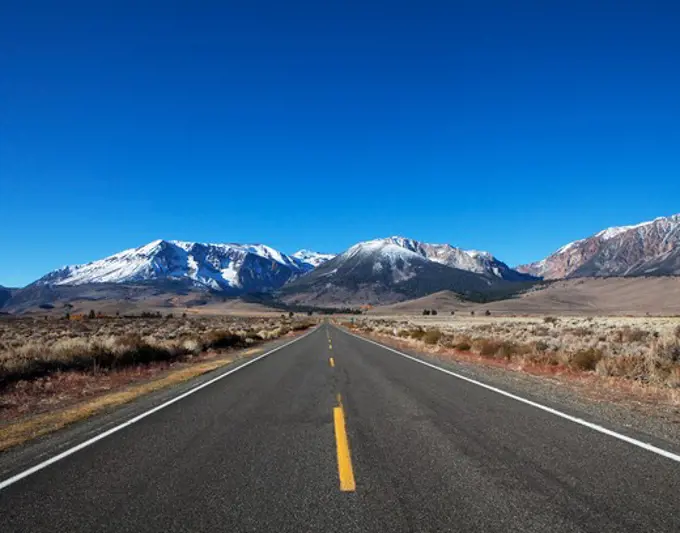 Road leading towards a mountain range