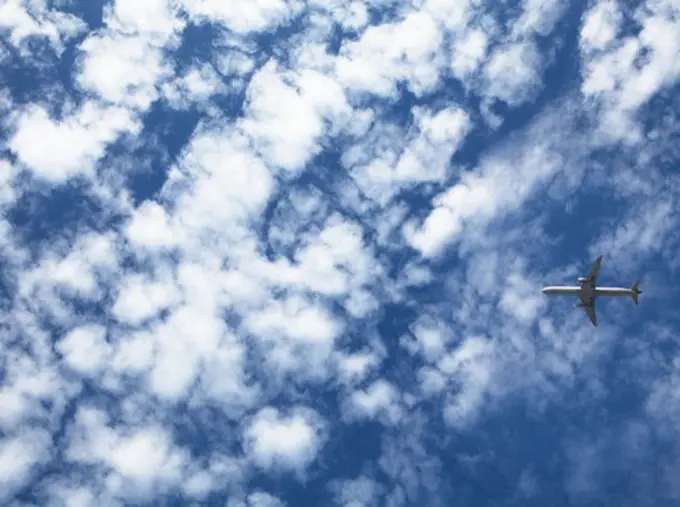 Airplane in flight against the cloudy sky