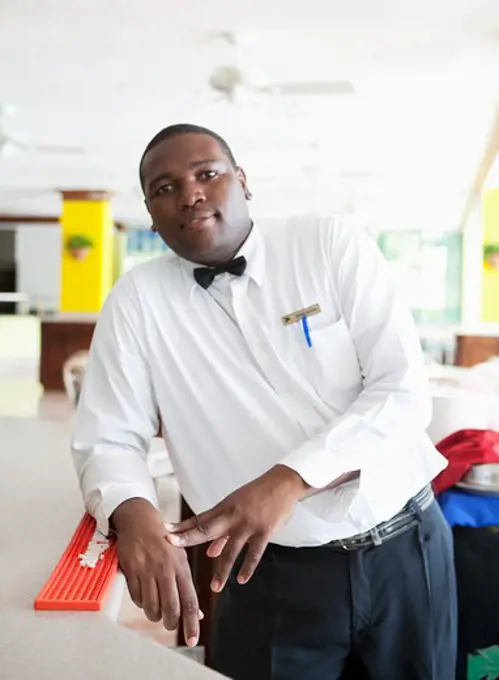 Bartender leaning at the counter of a hotel, Jamaica