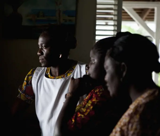 Three women looking through a window, Jamaica