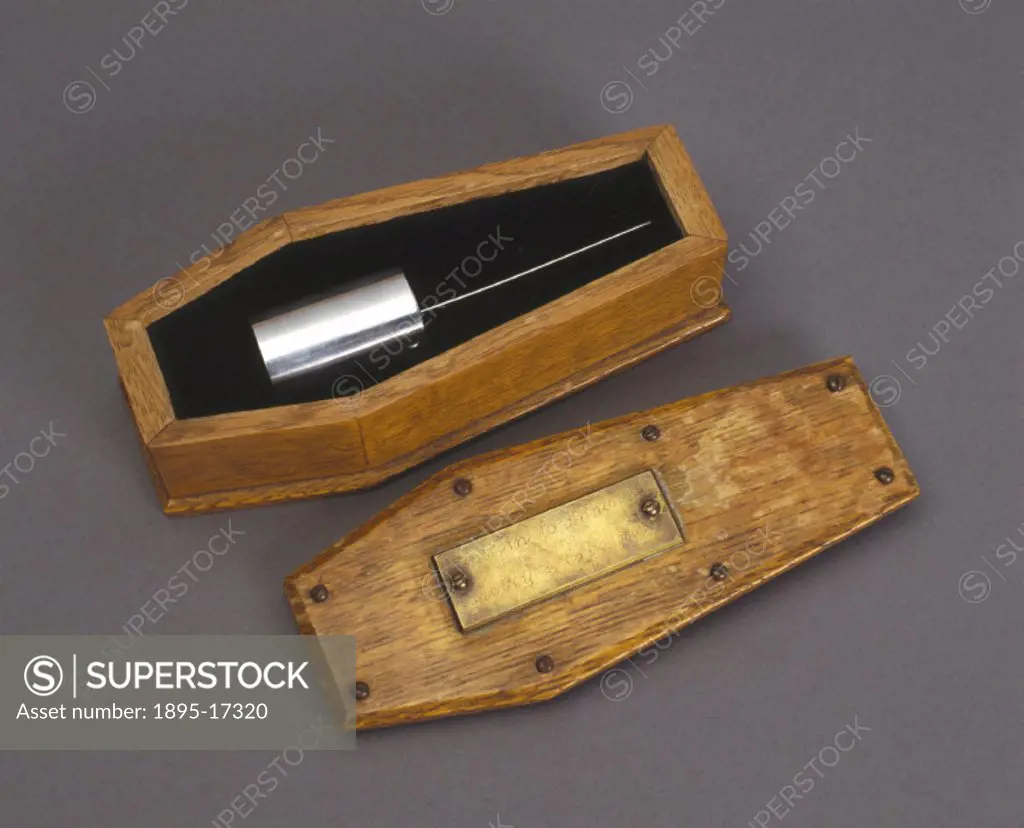 Metal cylinder in a coffin-shaped oak container, presented to Sir Monty Finniston. This object was purchased at a Bonhams Auction in aid of the Britis...