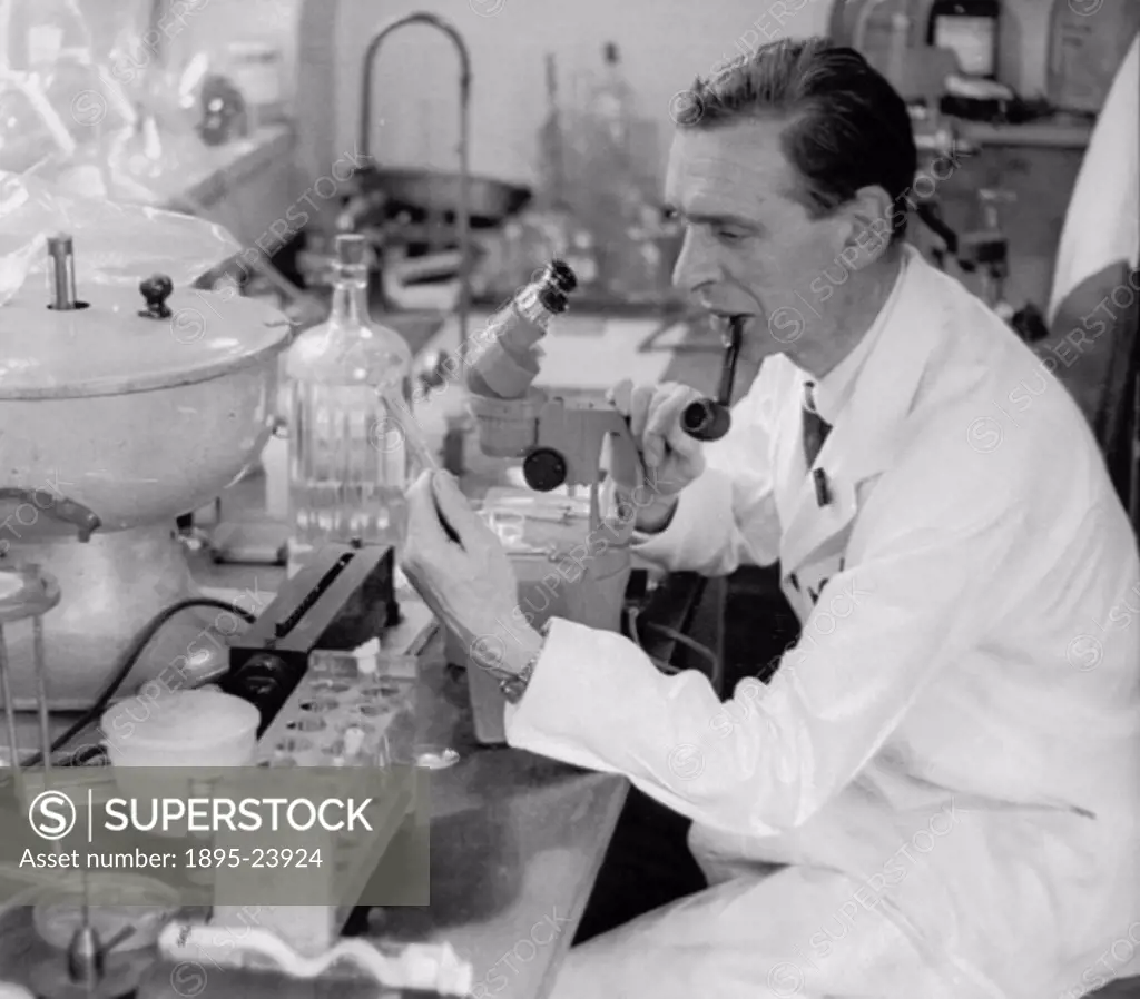 A white-coated scientist examines a test tubes contents. IVF (in vitro fertilisation) is the fertilisation of egg and sperm outside the body (hence t...