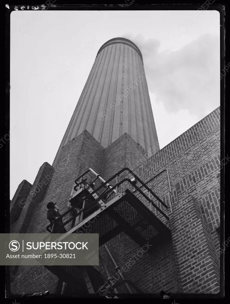 A photograph of a chimney at Battersea Power Station in London, taken by Tomlin for the Daily Herald newspaper on 17 January, 1934.  The man on the ga...