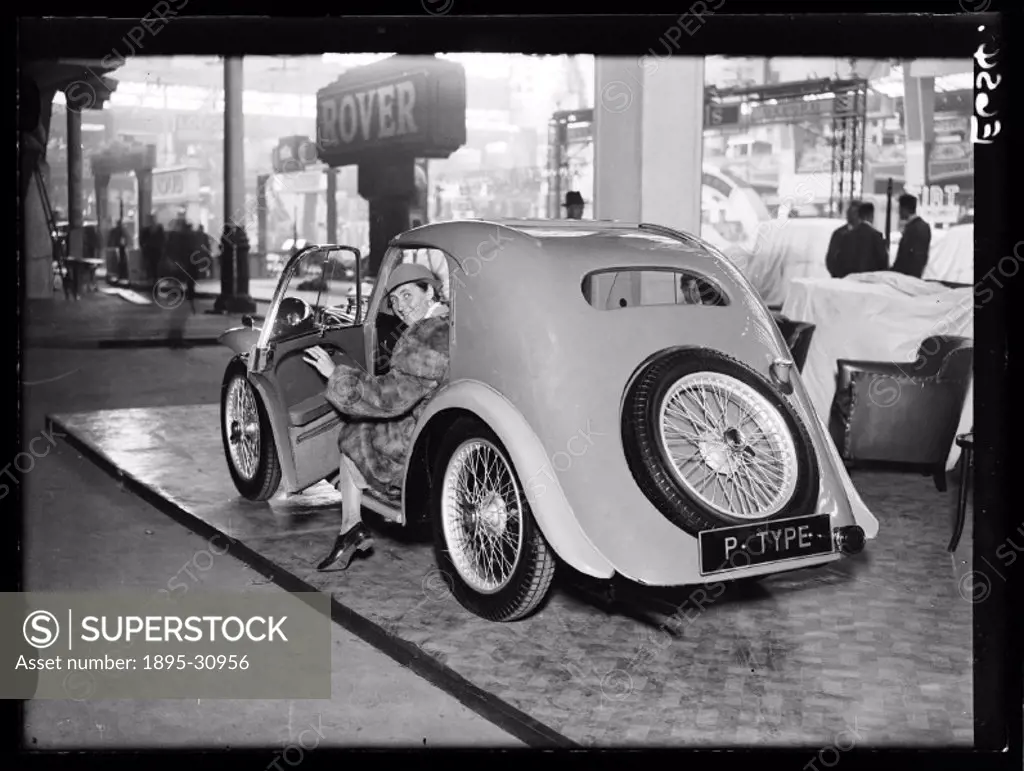 A photograph of an MG Midget PA Airline Coupé on display at the Motor Show in Olympia, London, taken by Edward Malindine for the Daily Herald newspape...