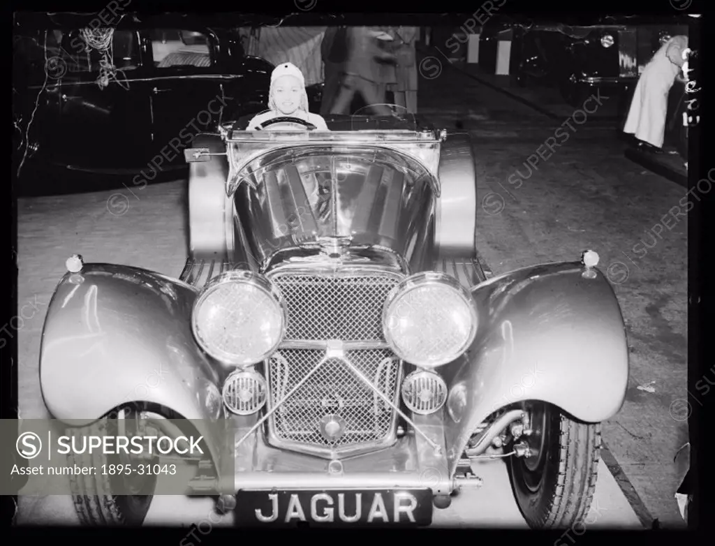 A photograph of a Jaguar SS 100 3.5 litre Saoutchik Roadsteron display at the Motor Show in Olympia, London, taken by Edward Malindine for the Daily H...