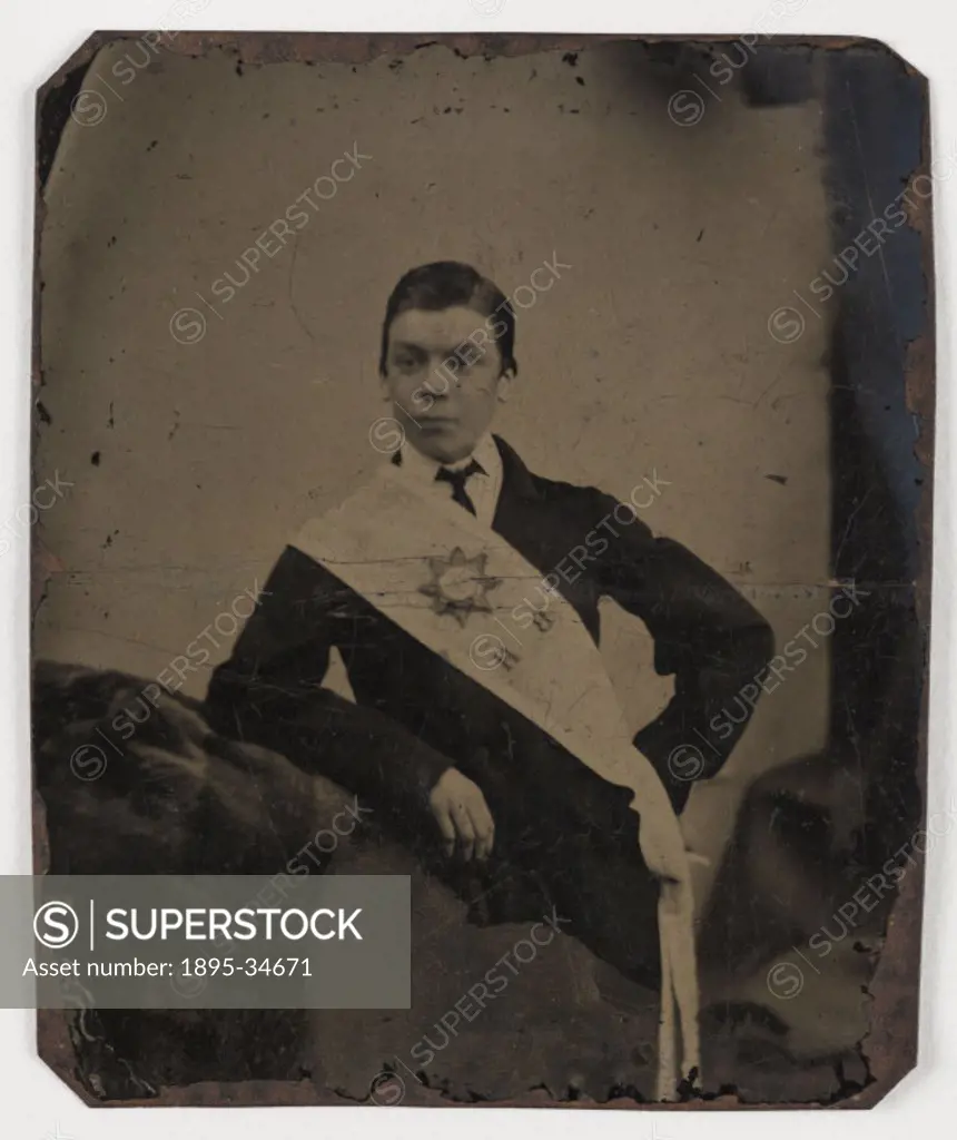 A tintype photograph of a young man wearing a sash, taken by an unknown photographer in about 1880.  The sash bears a star motif and the initial ´BH´ ...