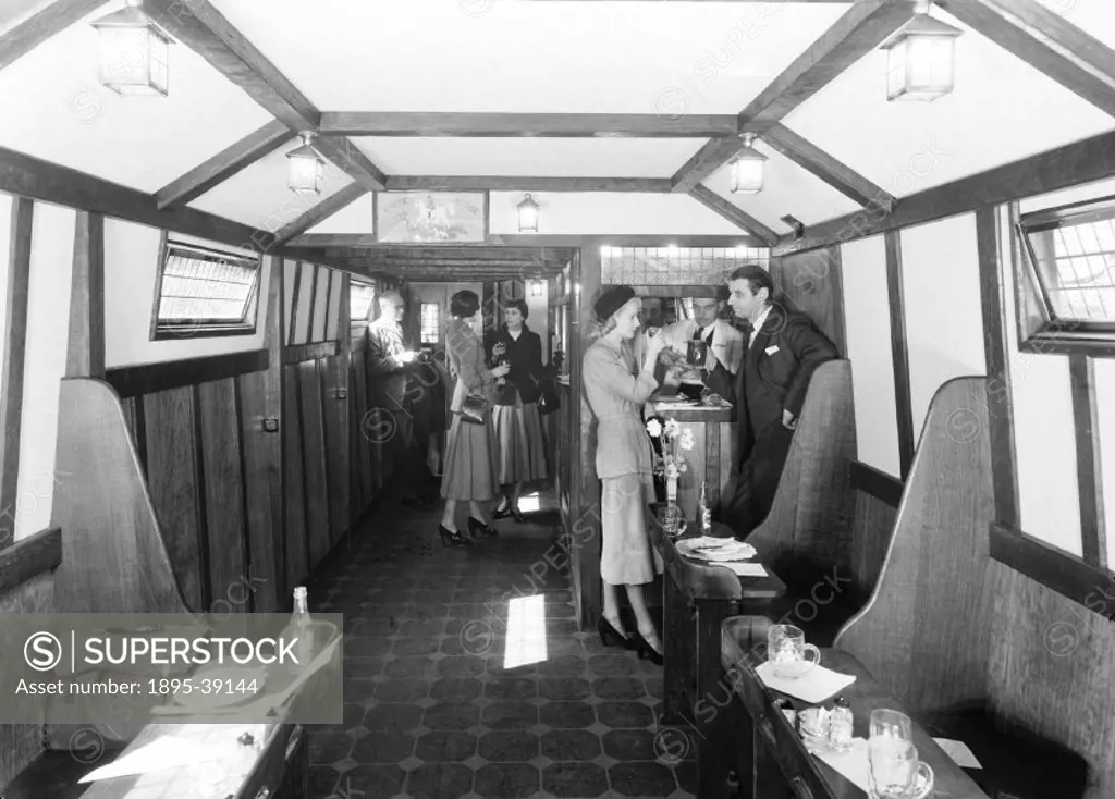 Passengers at the bar inside a tavern car, 1949.   Tavern cars ran on the British Railways Southern Region. Pasengers could buy food and drinks in the...