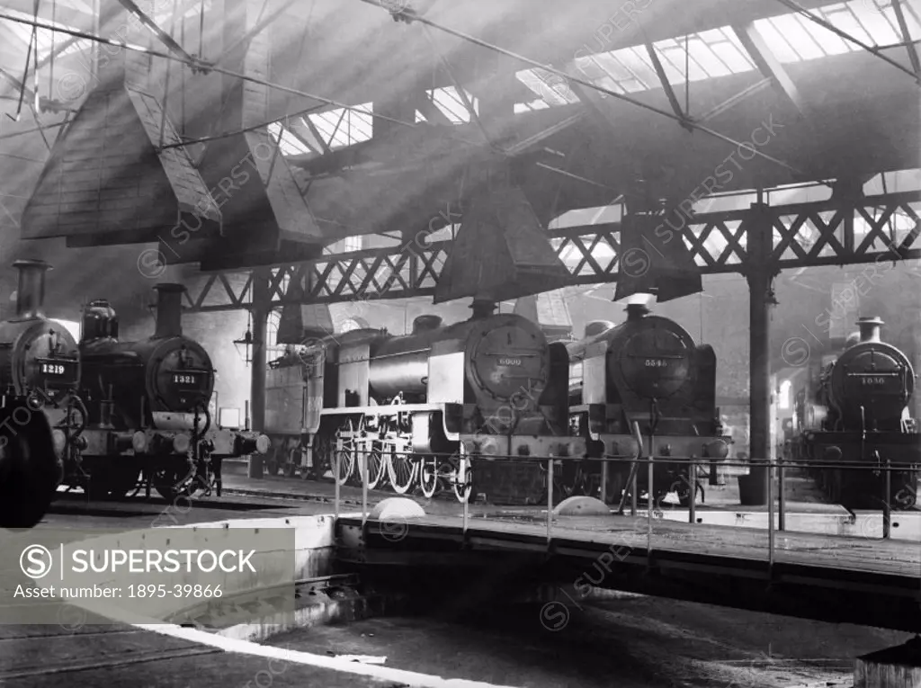 Kentish Town Locomotive shed, London, by Godfrey Soole, 1934. This photograph shows locomotives around the turntable.   Turntables were used to transf...