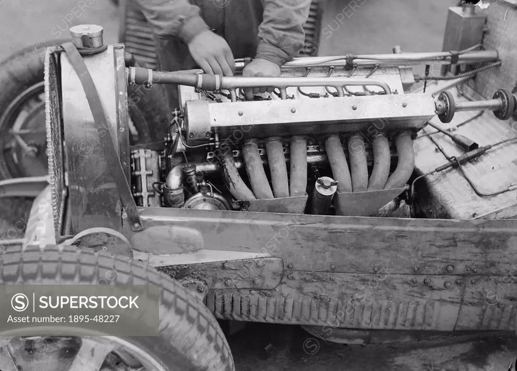 A mechanic working on the engine of a Bugatti, Nurburgring, Germany, 1931.Photograph by Zoltan Glass. A mechanic works on the engine of a Bugatti Type...