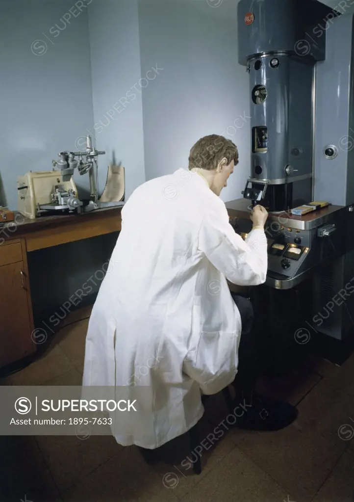 Reconstruction in the Wellcome Gallery, Science Museum, showing a scientist using an electron microscope. This type of microscope uses a stream of ele...