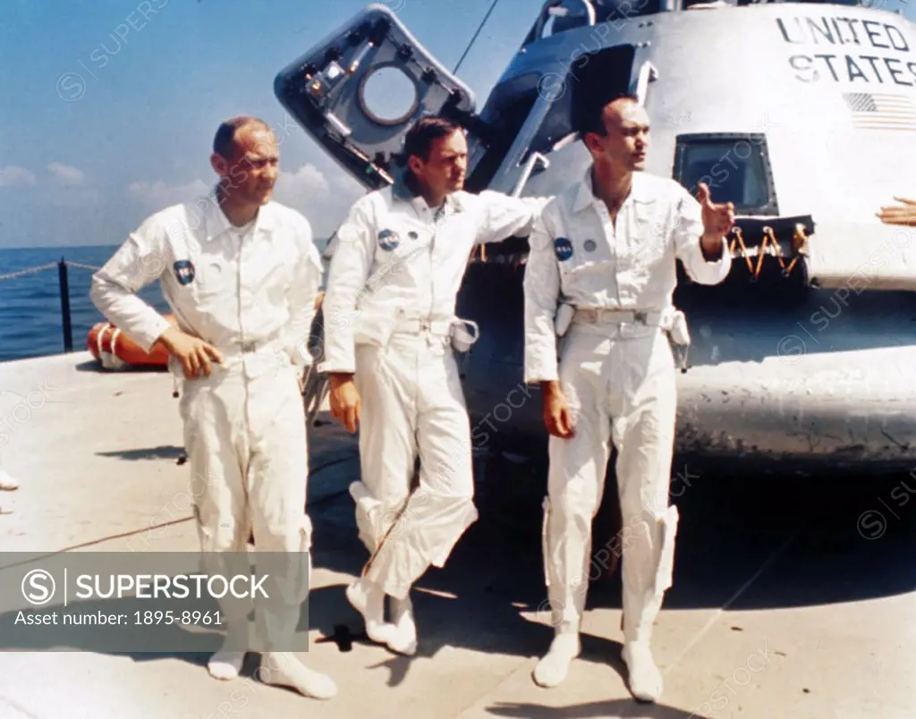 Neil Armstrong, Michael Collins and Edwin Buzz’ Aldrin standing by a boiler plate Apollo capsule on the deck of the NASA vessel Retriever during wate...