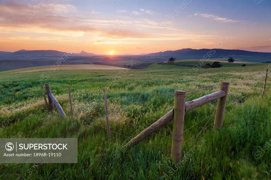 Wide angle view of a colorful sunset sky over the overberg farmlands. Caledon Area, Western Cape, South Africa.