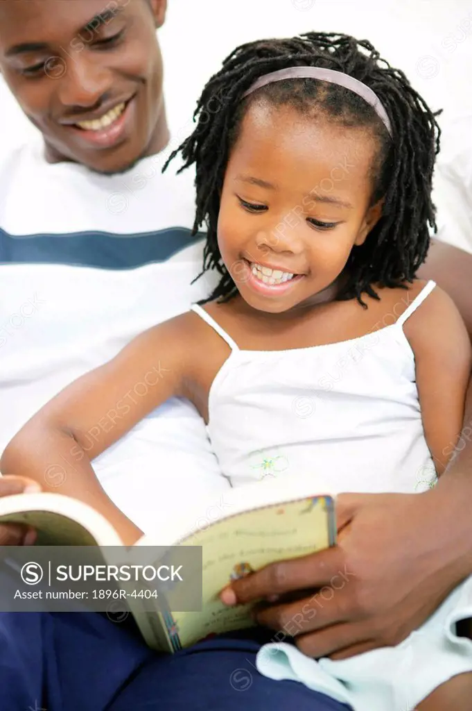 Young Girl Reading a Book with her Father  Cape Town, Western Cape Province, South Africa