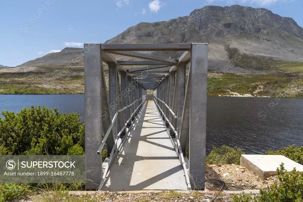 Buffels River, Western Cape, South Africa, Buffels River Dam, metal walkway across the reservoir and the Hottentots Holland mountains background near Rooiels, Western Cape