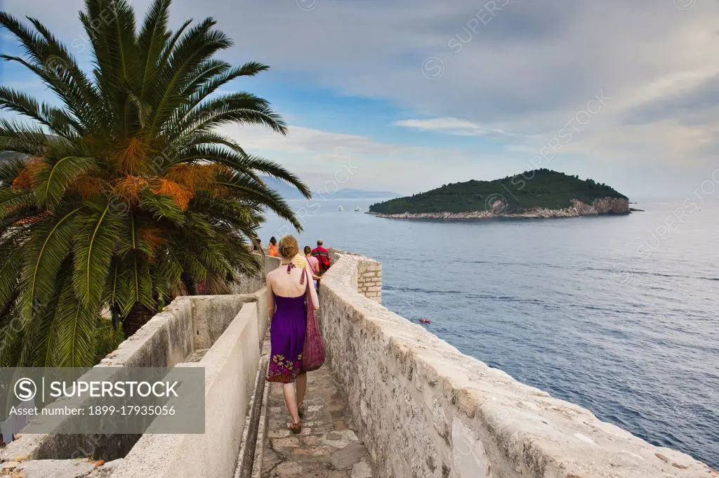 Photo of a tourist walking on Dubrovnik City Walls, Dubrovnik Old Town, Croatia