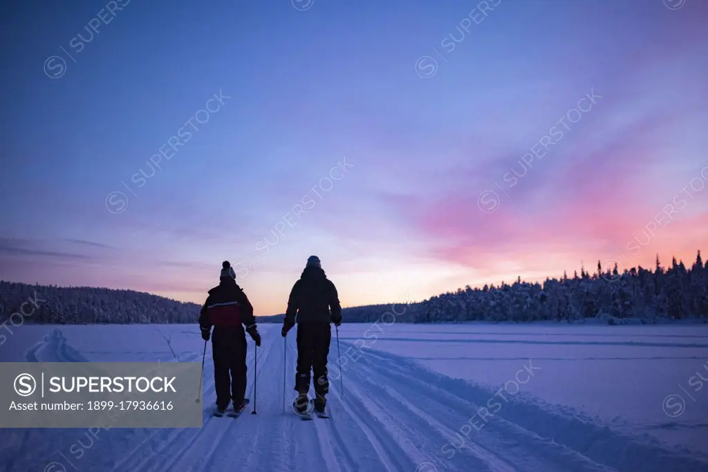 Skiing on the frozen lake at Torassieppi at sunset, Lapland, Finland