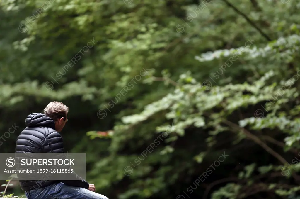 Young man praying alone in nature.  France. 