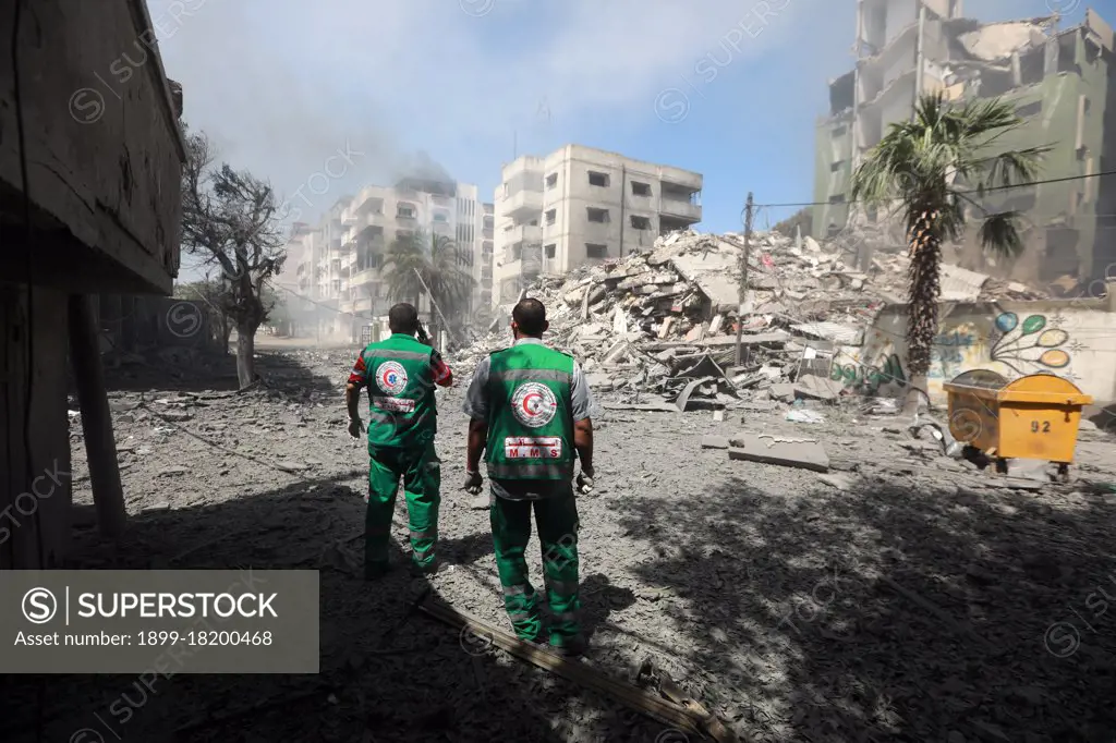 Medics inspect the rubble of a destroyed residential building that was hit by an Israeli airstrike, in Gaza City.