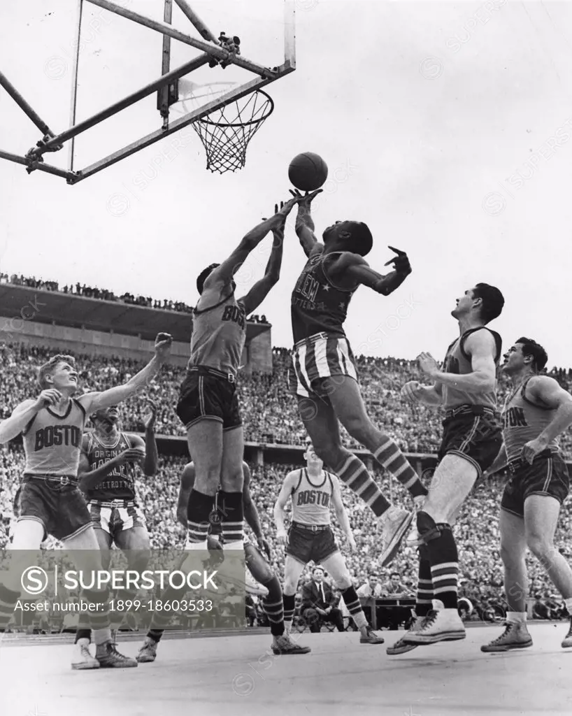 A member of the Harlem Globetrotters, the famous all-African-American US professional basketball team, goes up to score a lay-in shot during a game played against the Boston Celtics before a sell-out crowd in West Berlin. The Globetrotters made numerous overseas tours to perform before millions of sports enthusiasts the world over, West Berlin, Germany, 8/22/1951. (Photo by United States Information Agency/PhotoQuest/Getty Images)