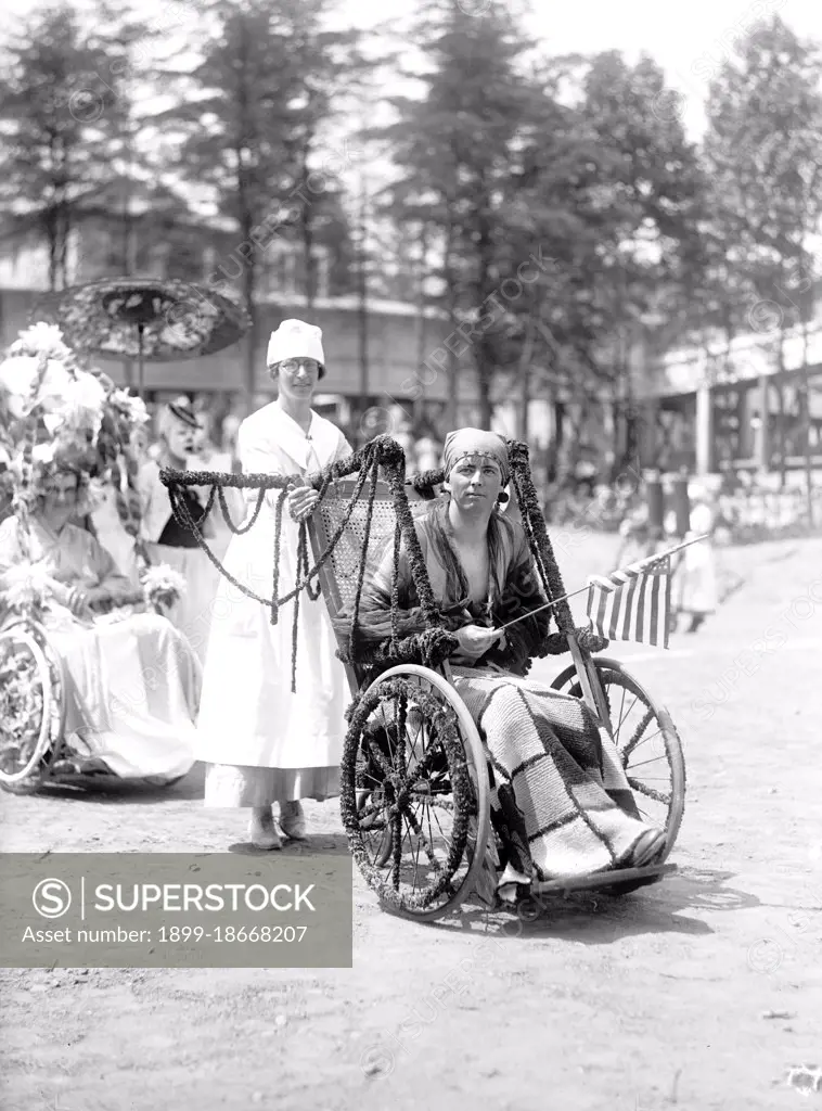 Wounded WW I soldiers at Walter Reed Hospital participate in a 4th of July wheel chair parade circa 1919 .