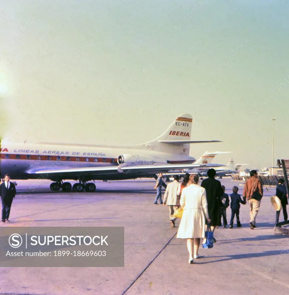 Airplane passengers walking on the tarmac at the Madrid Spain airport before boarding a plane circa 1969.