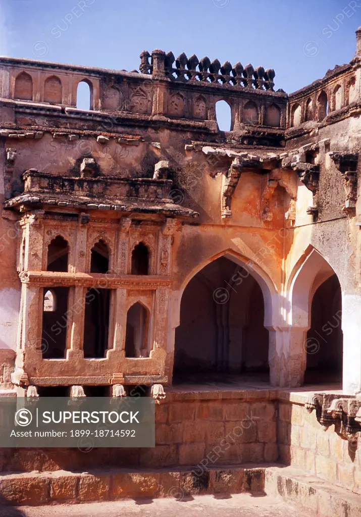 The Queen's Bath is part of the Royal Enclosure and the tank (pool) in the middle is believed to have been filled with perfumes and flowers. Hampi is a village in northern Karnataka state. It is located within the ruins of Vijayanagara, the former capital of the Vijayanagara Empire. Predating the city of Vijayanagara, it continues to be an important religious centre, housing the Virupaksha Temple, as well as several other monuments belonging to the old city.