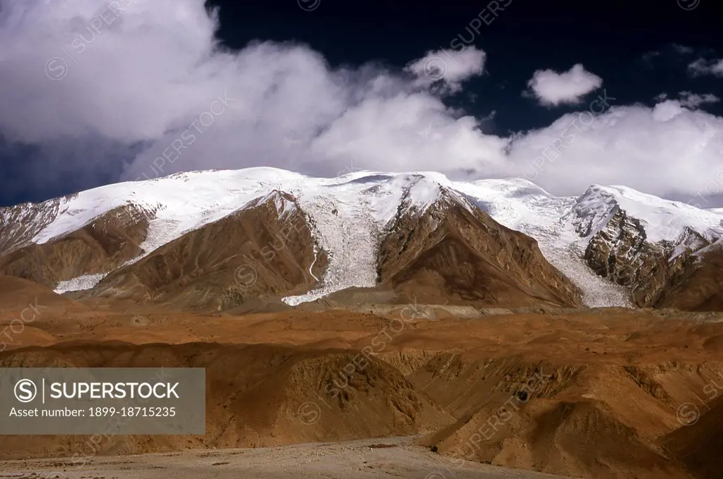 The Pamir Mountains are a mountain range in Central Asia formed by the junction of the Himalayas, Tian Shan, Karakoram, Kunlun and Hindu Kush mountain ranges. They are among the world's highest mountains and since Victorian times they have been known as the 'Roof of the World', a probable translation from the Persian. The Zhongba Gonglu or Karakoram Highway is an engineering marvel that was opened in 1986 and remains the highest paved road in the world. It connects China and Pakistan across the Karakoram mountain range, through the Kunjerab Pass, at an altitude of 4,693 metres (15,397 ft).