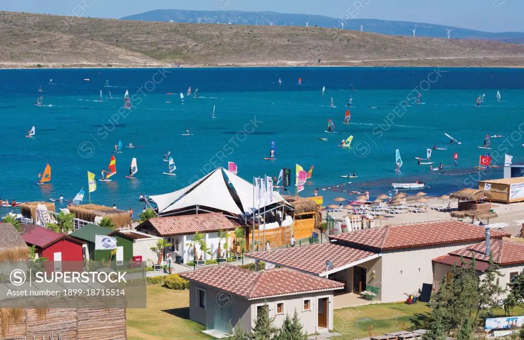 Alacati, Izmir Province, Turkey. Windsurfing. Windmills on hill behind.