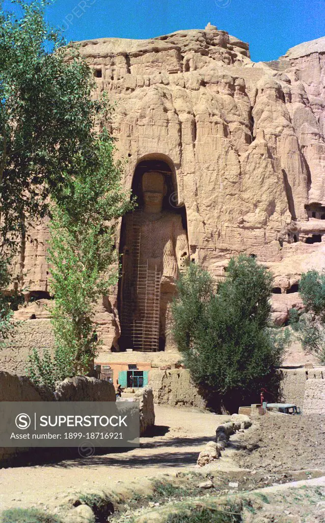 The Buddhas of Bamiyan were two 6th century monumental statues of standing buddhas carved into the side of a cliff in the Bamiyan valley in the Hazarajat region of central Afghanistan, situated 230 km (143 miles) northwest of Kabul at an altitude of 2,500 meters (8,202 ft). Built in 507 CE, the larger in 554 CE, the statues represented the classic blended style of Gandhara art. The main bodies were hewn directly from the sandstone cliffs, but details were modeled in mud mixed with straw, coated with stucco. This coating, practically all of which was worn away long ago, was painted to enhance the expressions of the faces, hands and folds of the robes; the larger one was painted carmine red and the smaller one was painted multiple colors. The lower parts of the statues' arms were constructed from the same mud-straw mix while supported on wooden armatures. It is believed that the upper parts of their faces were made from great wooden masks or casts. The rows of holes that can be seen in p