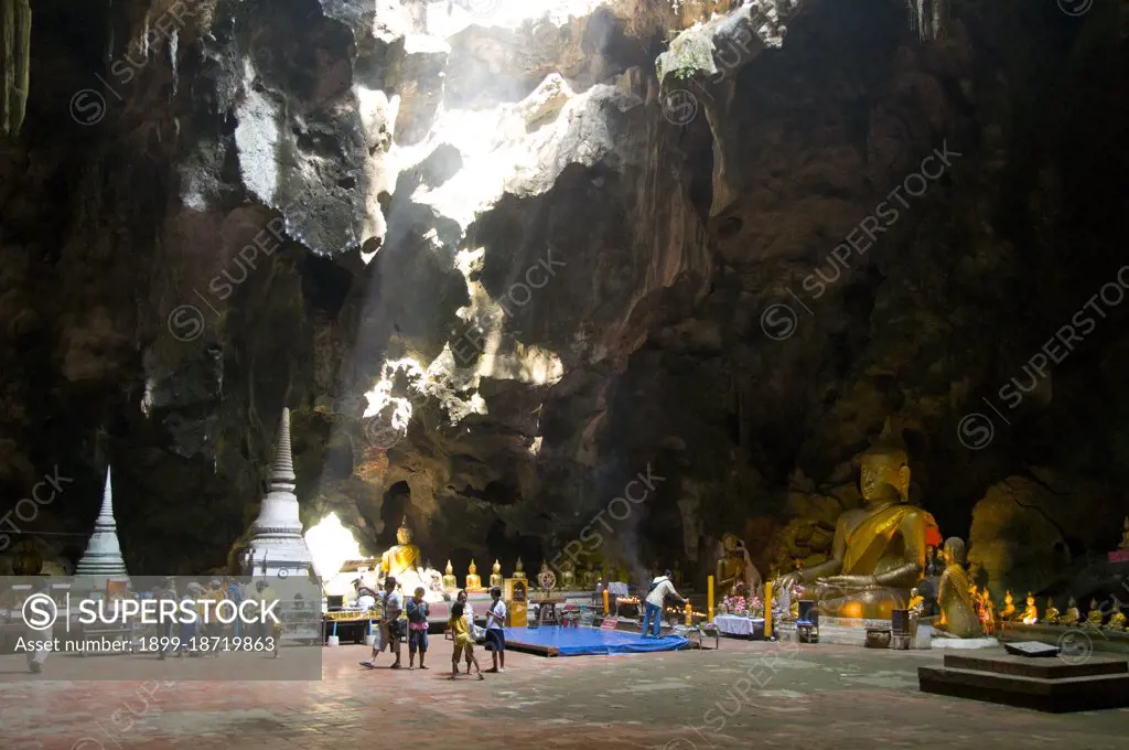 Tham Khao Luang is a large cave consisting of three linked chambers and is distinguished by many hanging stalactites and Buddha images, including a phra non or reclining Buddha. The main bronze image was cast on the orders of King Chulalongkorn (Rama V) and dedicated to his illustrious predecessors, Kings Rama III and Rama IV. There is a natural opening in the ceiling of the second, main chamber, through which daylight streams illuminating the images within. 