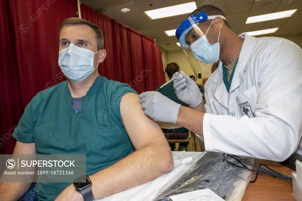 Reportage:   Army Col. Sean Dooley, a doctor at Walter Reed National Military Medical Center, receives a COVID-19 vaccination, Walter Reed National Military Medical Center, Bethesda, Md., Dec. 14, 2020.