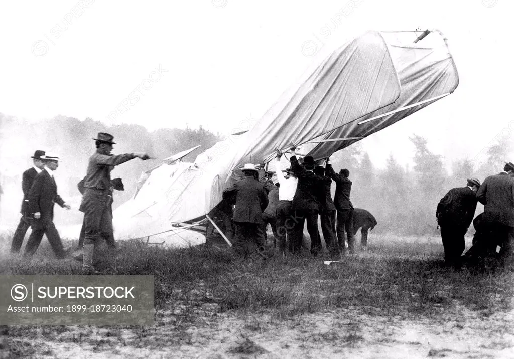 1908 - Bystanders help extricate the mortally wounded US Army (USA) Lieutenant (LT) Thomas Selfridge from the wreck of the Wright Brothers Flyer after its crash at Fort Myer, Virginia (VA). At right, several men attend the injuries of Orville Wright, who lies on the ground at their feet. 