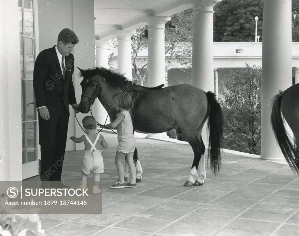 22 June 1962, White House - JFK, his children, John and Caroline, and pony Macaroni outside the Oval Office.