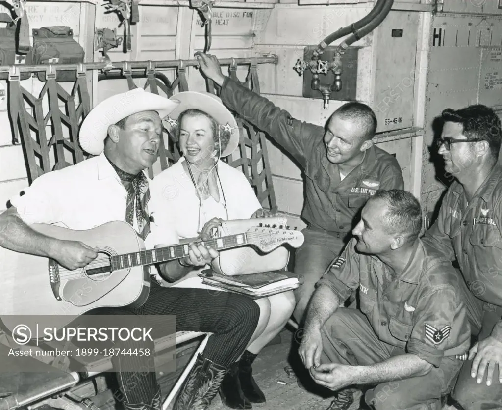 Roy Rogers and Dale Evans entertain crew members of an Air Force C-123 Provider during the last leg of their Vietnam tour. Crew members are (l-r) Airman 2nd Class Cyril F. Crawley, SSGT. Francis K Ssutek , and Tech Sgt Eddie Miller. Nov 1966. 