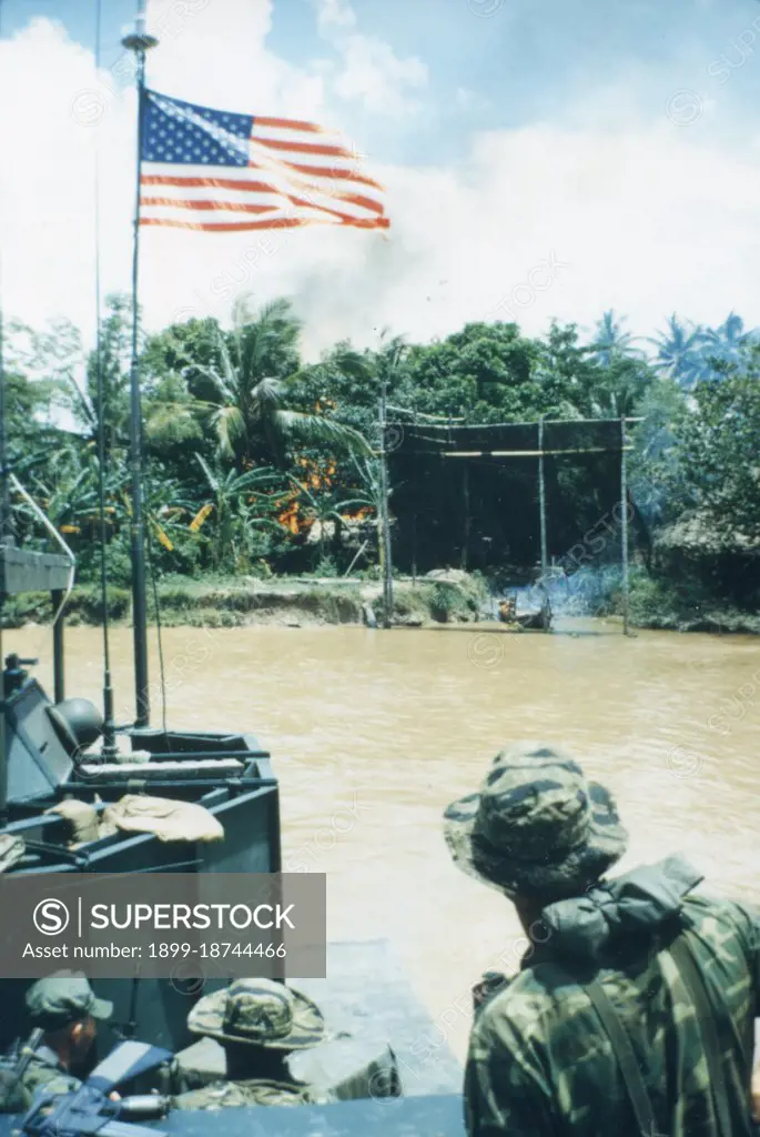 A heavily armed "Mike" boat carrying members of a US Navy SEAL team departs the site of a Viet Cong fortification on the Bassac River which was destroyed by the SEALS during Operation Crimson Tide. Sept 1967, Mekong Delta, Vietnam. PhotoQuest/ Gety Images.