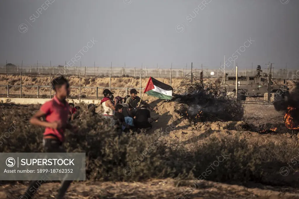 Palestinian demonstrators participate during a demonstration near the border between Israel and the Gaza Strip. A march organized by Palestinian factions on the border between the Gaza Strip and Israel in protest against the continuation of the siege imposed on the Gaza Strip and Israel. The entry of construction materials into the Gaza Strip was delayed to rebuild the remnants of the last aggression last May. Palestinian Territories, Gaza Strip.