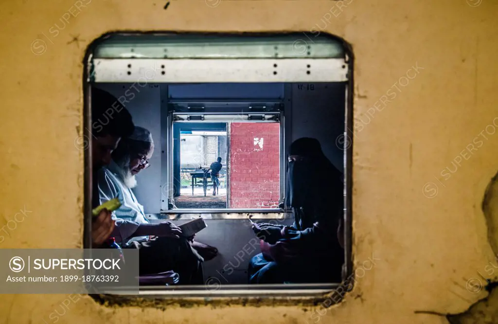 Muslim people reading Quran captured in a Beautiful Frame in a running Rail in Kamlapur Railway Station in Dhaka, Bangladesh.