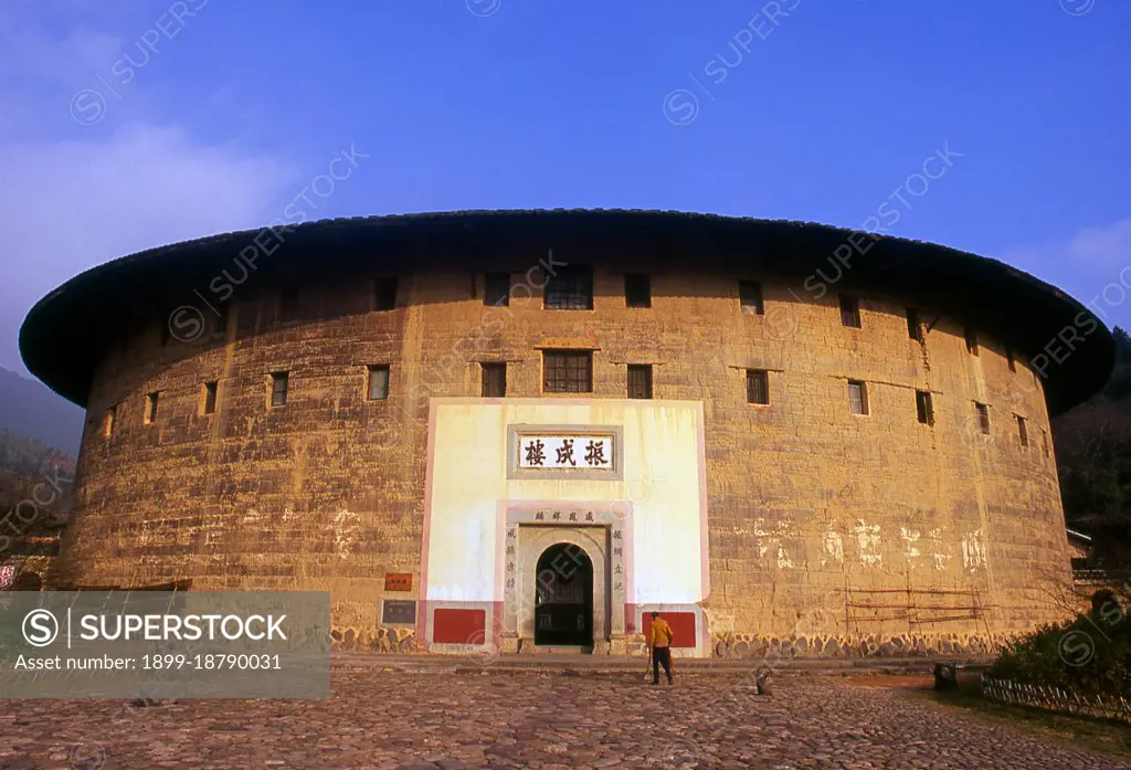 The Hakka (kejia in Mandarin; literally 'guest people') are Han Chinese who speak the Hakka language. Their distinctive earthen houses or tulou can be found in the borderland counties where Guangdong, Jiangxi and Fujian provinces meet. Communal entities, tulou are fortified against marauding bandits and generally made of compacted earth, bamboo, wood and stone. They contain many rooms on several storeys, so that several families can live together. The small, self-contained design is a common characteristic of Hakka dwellings (eg the Hakka walled villages at Kam Tin in Hong Kongs New Territories). Tulou come in a variety of styles, and can be circular, triangular, rectangular, octagonal or other shapes. The extraordinary round earth houses range in size from the small scale (around 12 rooms) to the large (up to 72 rooms). Most are three storeys high, but the largest have up to five storeys. Some tulou stand independently, while others cluster into groups. The tulou located in Hukeng inc