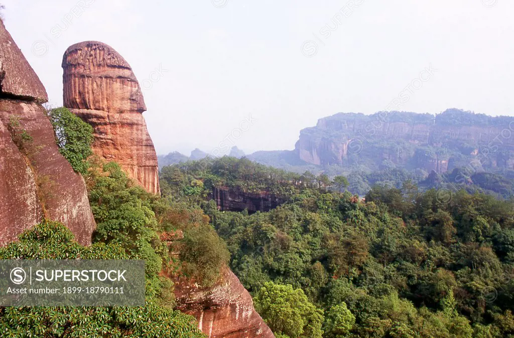 Danxia Mountain meaning Red Rosy Clouds Mountain, is a famous scenic area near Shaoguan city in the northern part of Guangdong Province. The area is formed from a reddish sandstone which has been eroded over time into a series of mountains surrounded by curvaceous cliffs and many unusual rock formations (Danxia Landform). There are a number of temples located on the mountains and many scenic walks. There is also a river winding through the mountains on which boat trips can be taken to enjoy the scenery. Particularly noted are two formations: a stone pillar called the Yangyuan (male/father stone) that bears a resemblance to a phallus and the Yinyuan hole, which somewhat resembles labia.