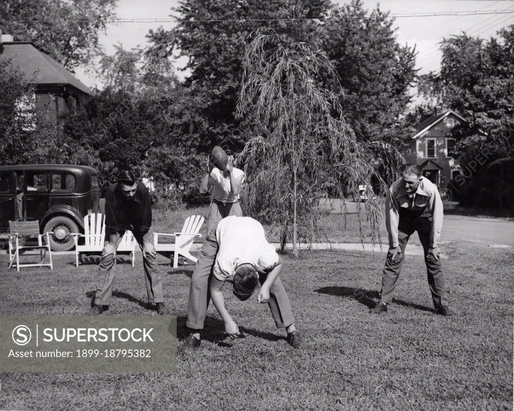 1948 - A father in Arlington, Virginia, Takes Time to Play Football with his Three Sons After Working Hours. 