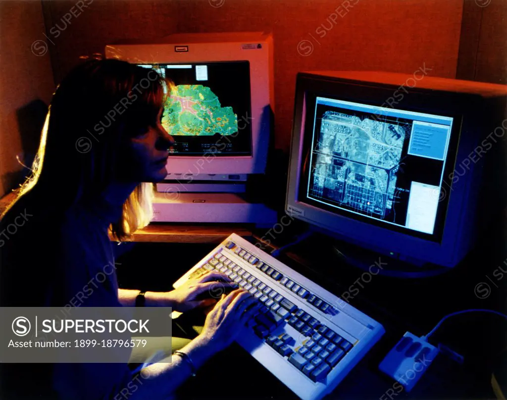 September 1996 - Scientist at computer analyzing multiple layers of data. 