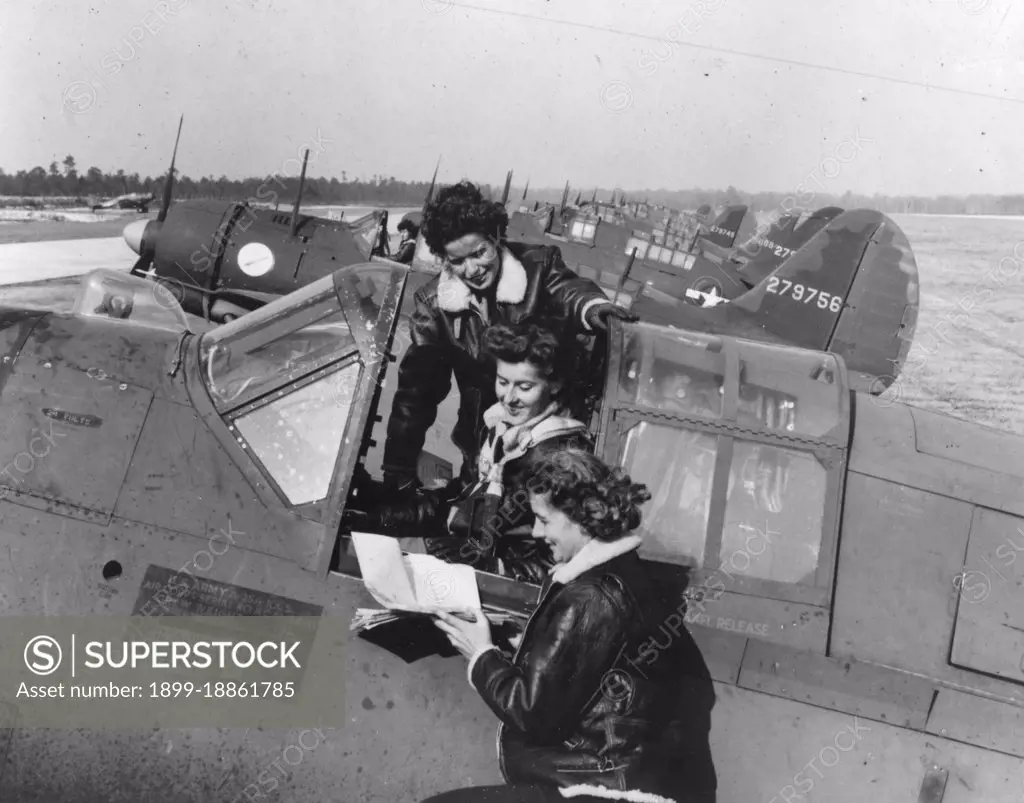 WASPs around a Curtiss A-25A making last minute check-ups before taking off. Army Air Field Camp Davis, NC. Circa 1944. 