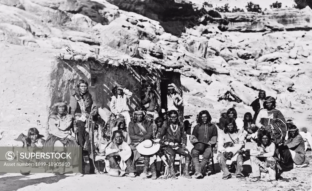 Paiute Indian group posed in front of adobe house ca. 1909.