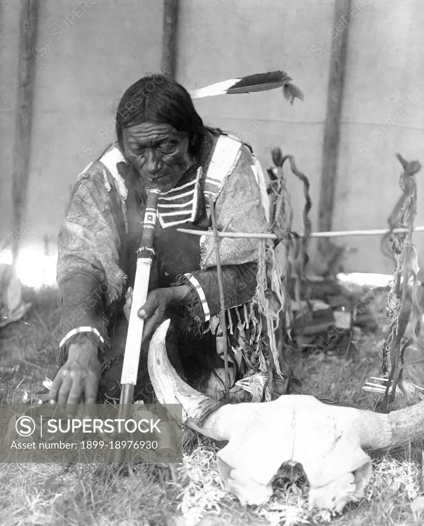 Edward S. Curtis Native American Indians - Dakota man with calumet kneeling by altar inside tipi ca. 1907. 