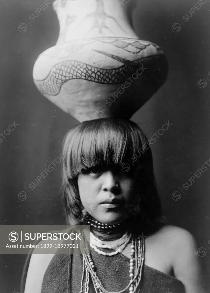 Edward S. Curits Native American Indians - San Ildefonso girl with large jar balanced on her head ca. 1927. 
