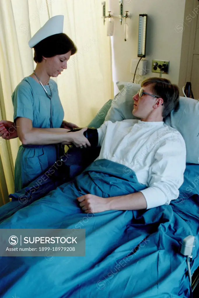 1977 - A US Army nurse takes a patient's blood pressure. 