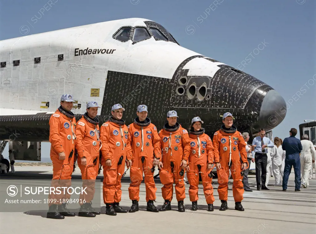 (16 May 1992) --- The seven crewmembers of STS-49 pose near Endeavour for a post-flight shot soon after getting their feet on terra firma following nine days in Earth orbit. Left to right are astronauts Richard Hieb, Kevin Chilton, Daniel Brandenstein, Thomas Akers, Pierre Thuot, Kathryn Thornton and Bruce Melnick. Brandenstein was mission commander; Chilton, pilot; and the others, mission specialists.. 