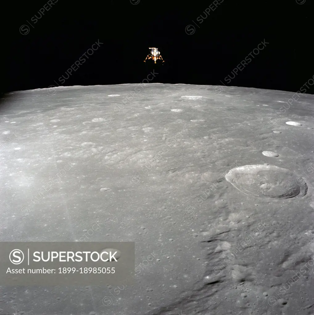  The Apollo 12 Lunar Module (LM), in a lunar landing configuration, is photographed in lunar orbit from the Command and Service Modules (CSM). The coordinates of the center of the lunar surface shown in picture are 4.5 degrees west longitude and 7 degrees south latitude. The largest crater in the foreground is Ptolemaeus; and the second largest is Herschel. Aboard the LM were astronauts Charles Conrad Jr., commander; and Alan L. Bean, lunar module pilot. Astronaut Richard R. Gordon Jr., command module pilot, remained with the CSM in lunar orbit while Conrad and Bean descended in the LM to explore the surface of the moon.. 