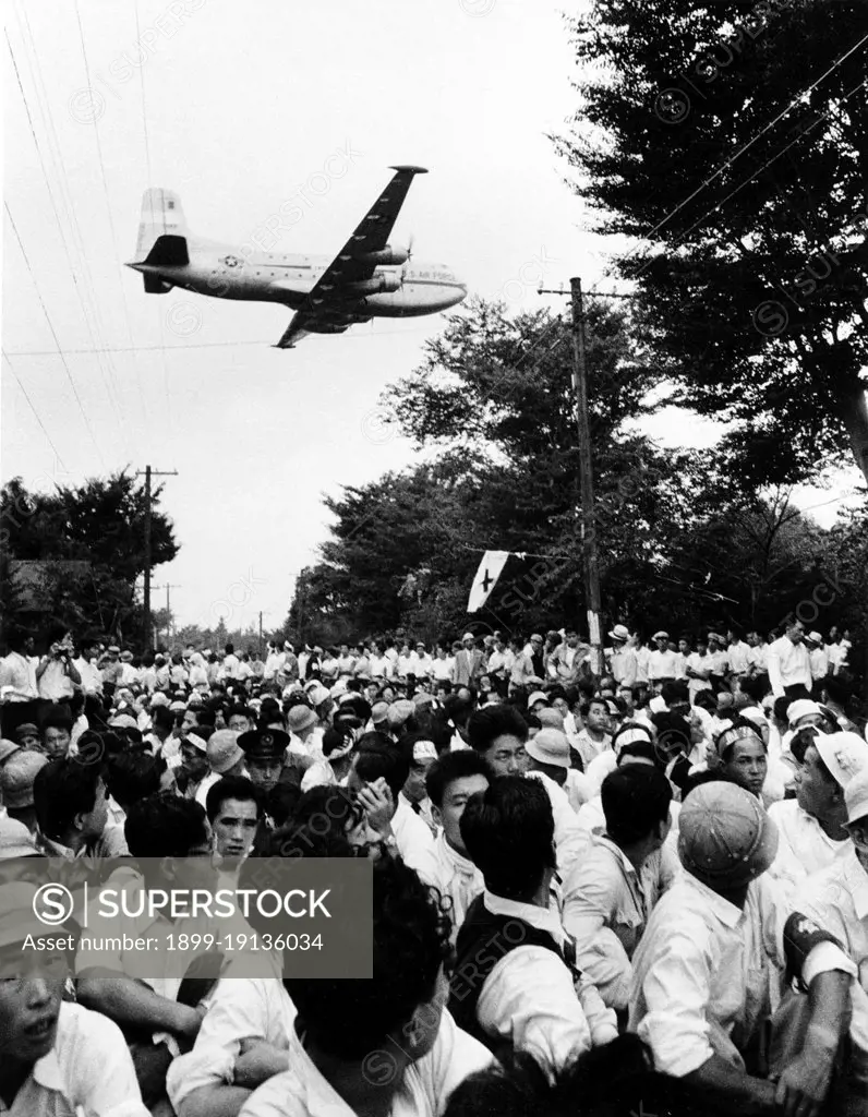 Japan: USAF military transport plane flies over a student sit-in in protest against the expansion of a US military base, Tachikawa, Tokyo. Ken Domon (1909 - 1990), 1955